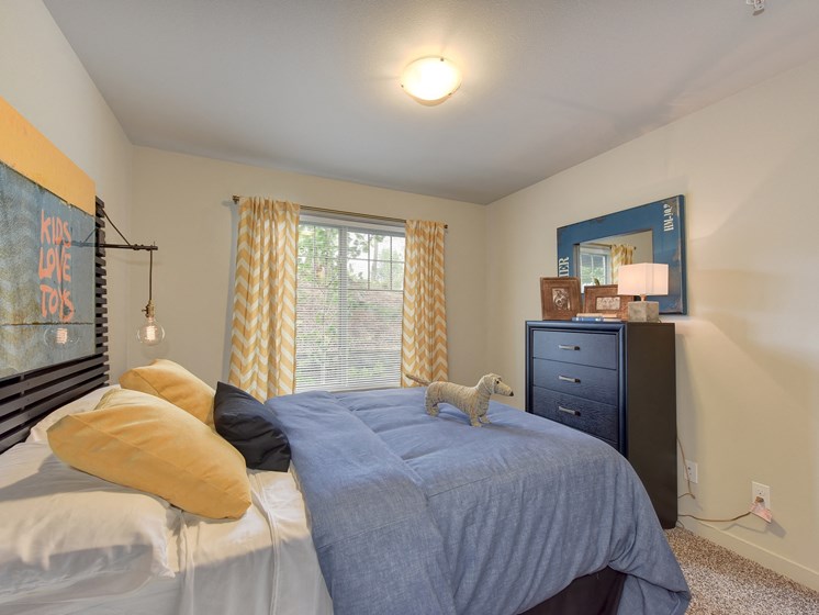 Master Bedroom with Kings Sized Mattress with Blue Comforter, Woven Dog, Black Dresser, Carpet and 